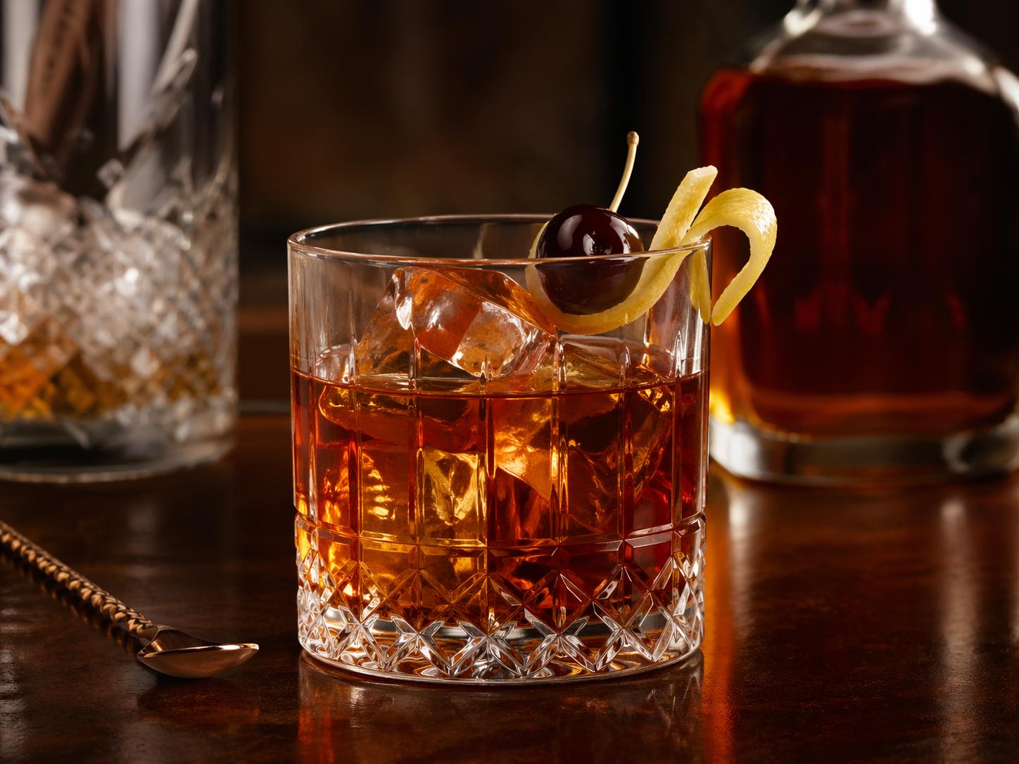Cóctel Vieux Carré servido en vaso bajo con hielo, cereza y piel de limón