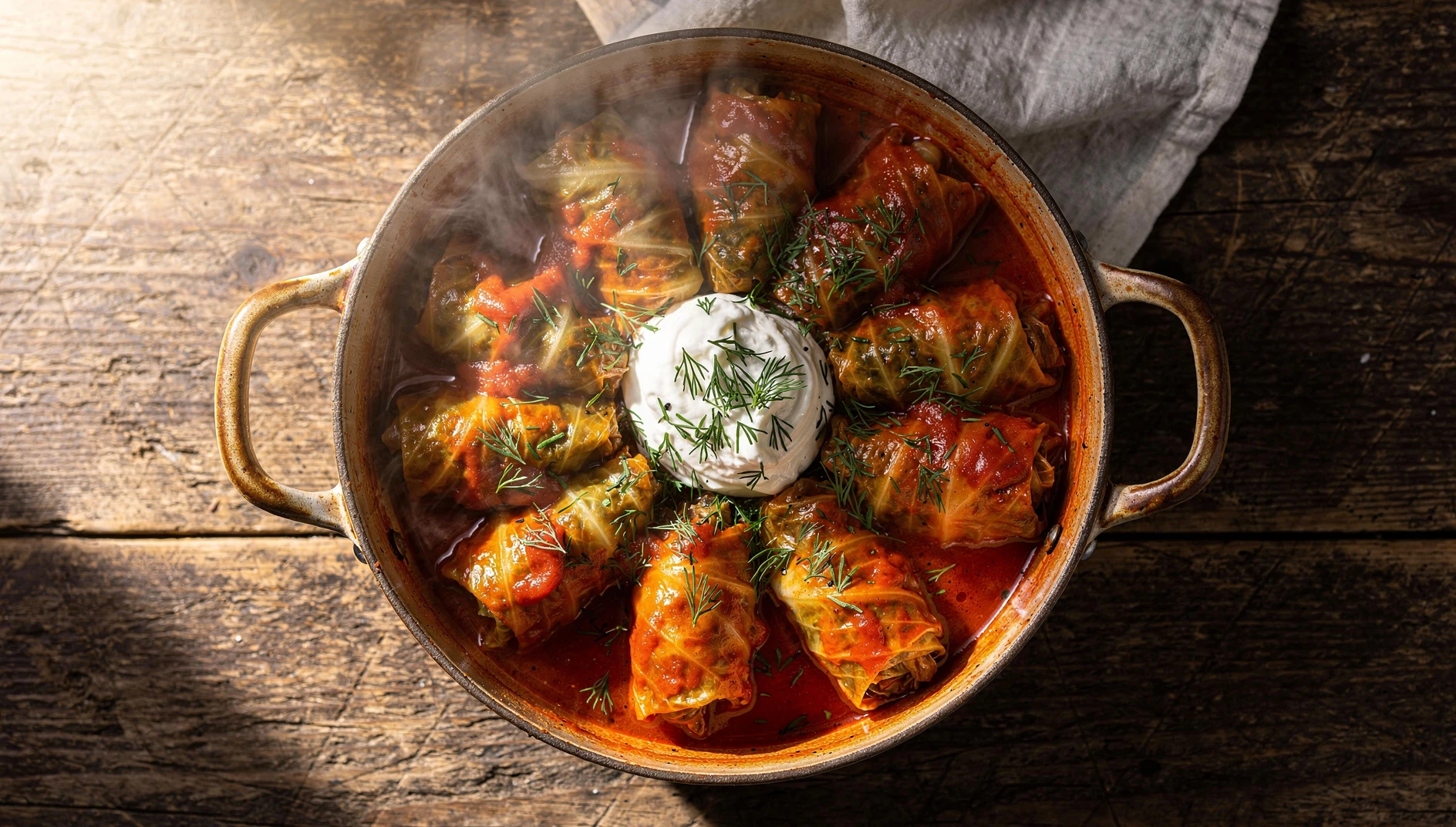 Golubtsy rusos en olla de cerámica con salsa de tomate, crema agria y eneldo fresco