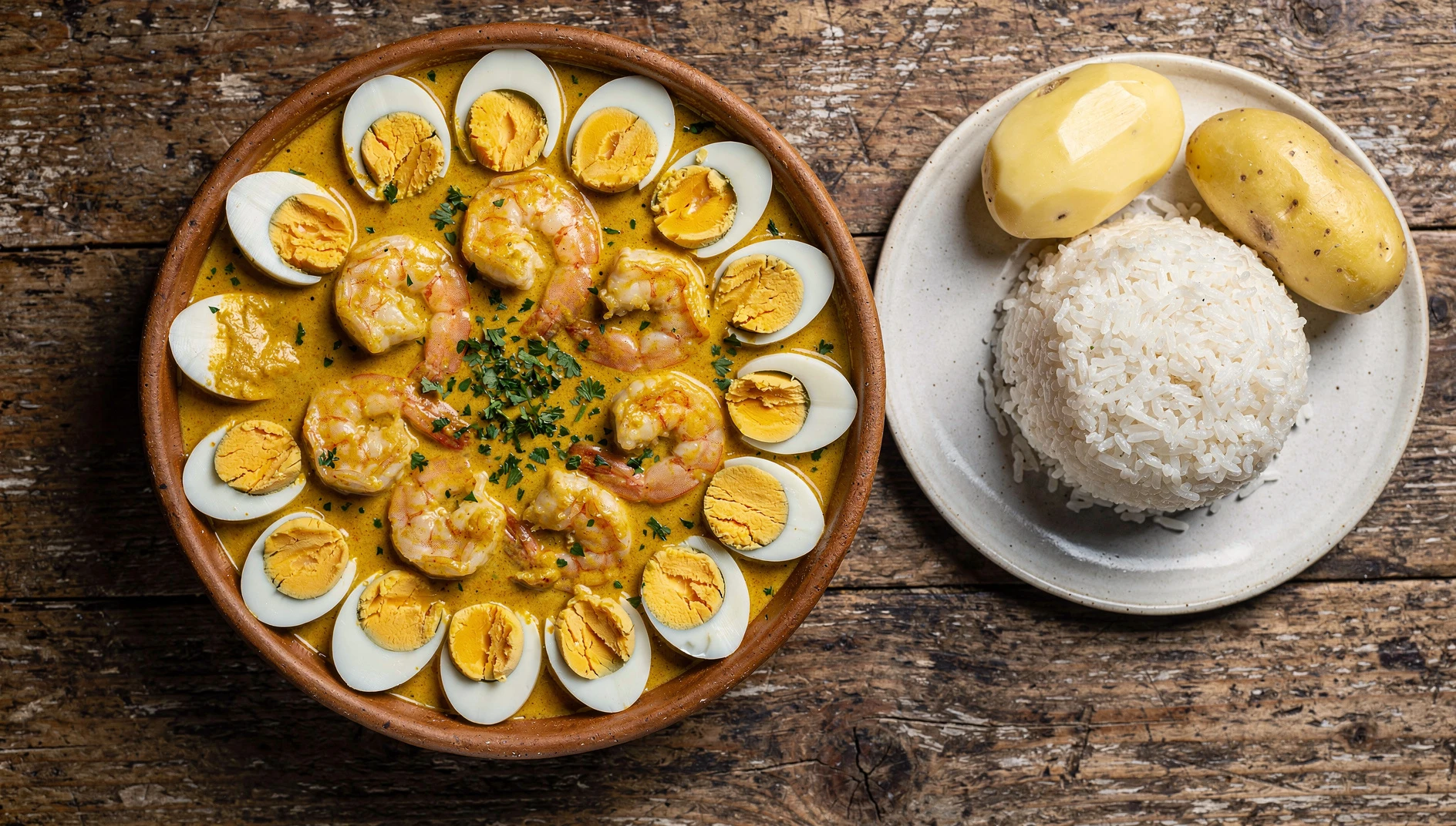 Tazón de ají de langostinos tumbesino con salsa cremosa de ají amarillo, arroz blanco y papas sancochadas