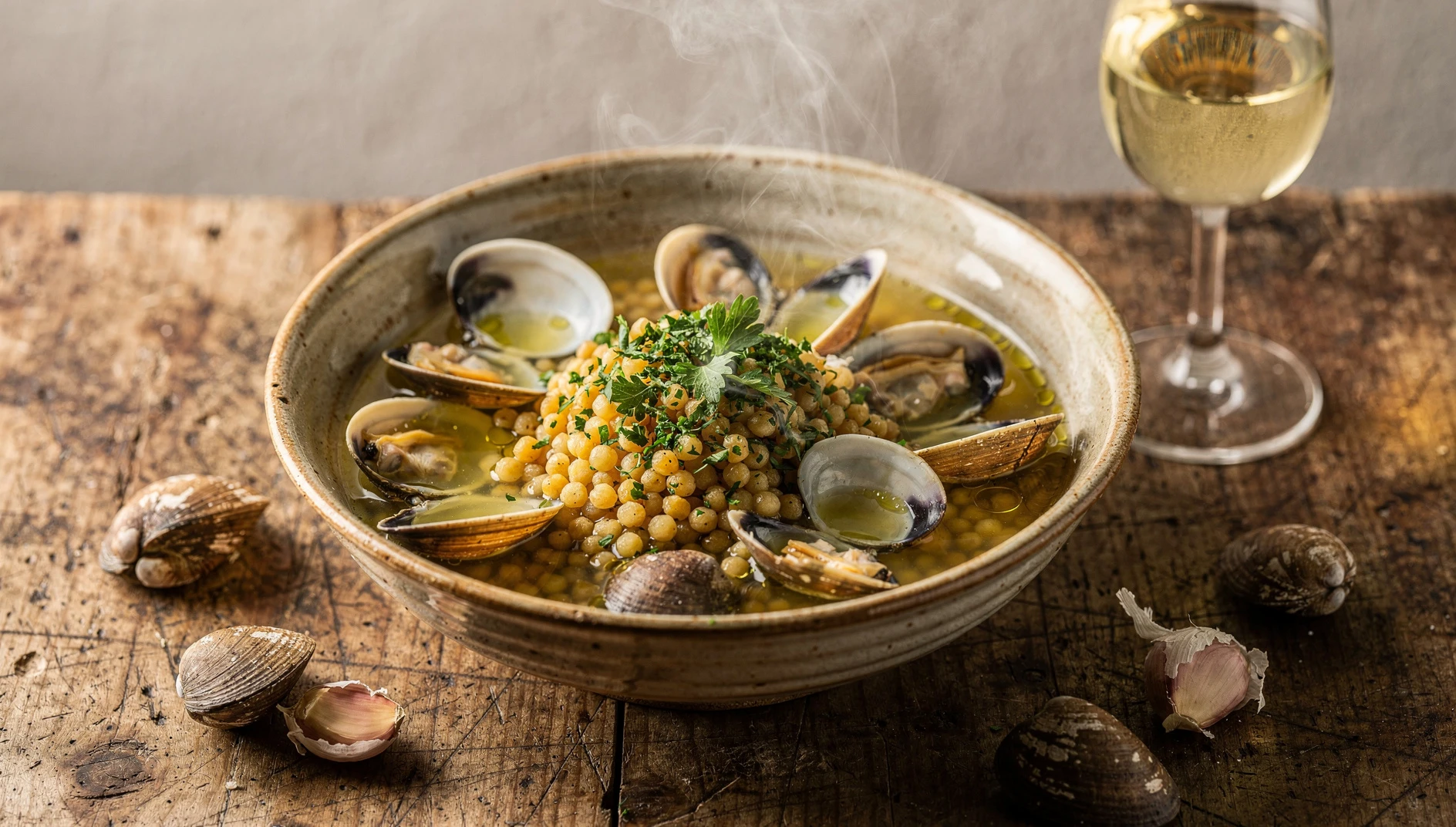 Bol de fregola sarda con arselle al vapor, perejil fresco picado y un chorrito de aceite de oliva virgen extra