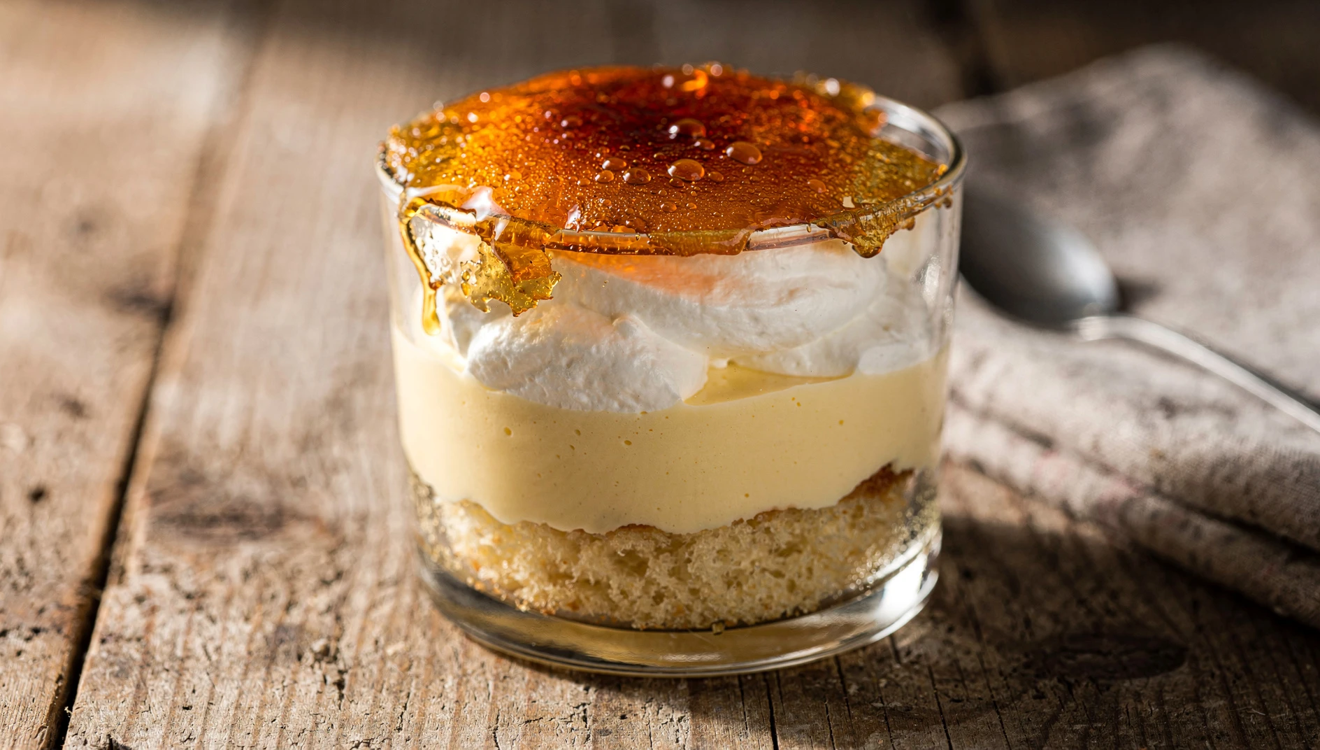 Goxua alavés casero en copa de cristal con capas de bizcocho, nata montada, crema pastelera y azúcar caramelizado