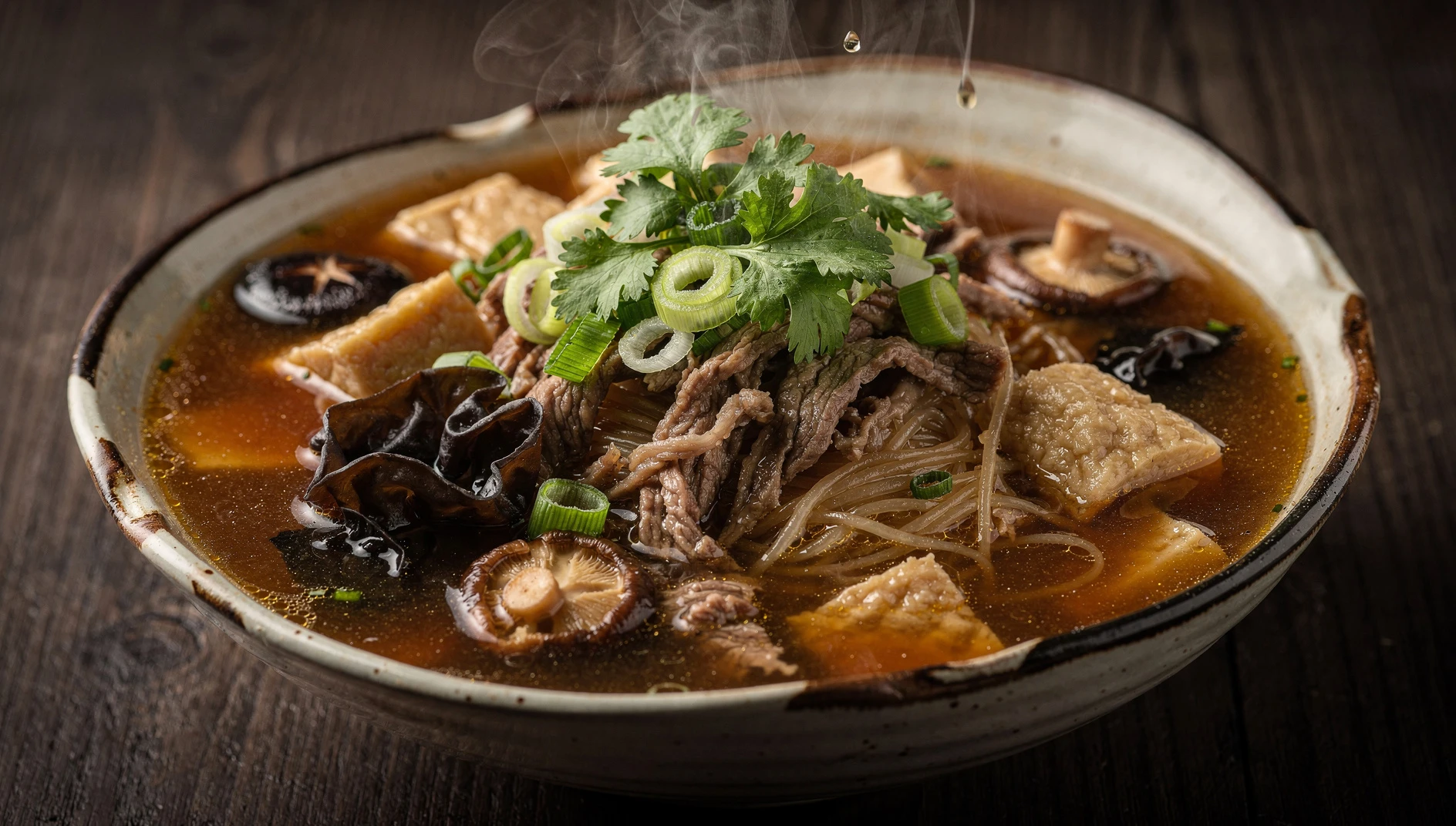 Bol de hula tang con caldo espeso, tiras de carne, setas shiitake, vermicelli y cilantro fresco