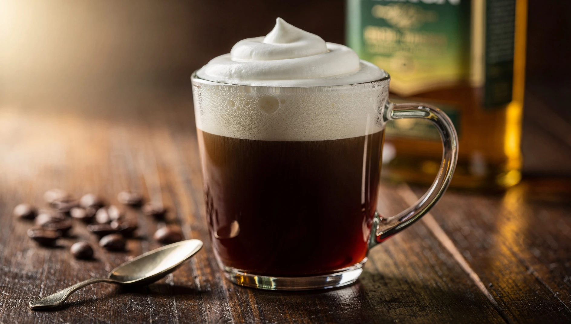 Copa de Irish Coffee con capa de crema flotante sobre café y whisky irlandés