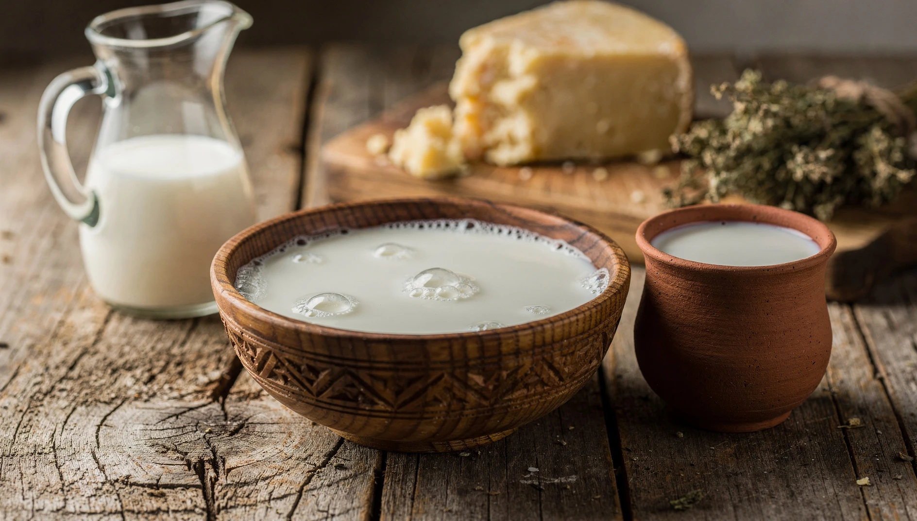 Kumis tradicional de Yakutia servido en bol de madera con jarra de leche fermentada sobre mesa rústica