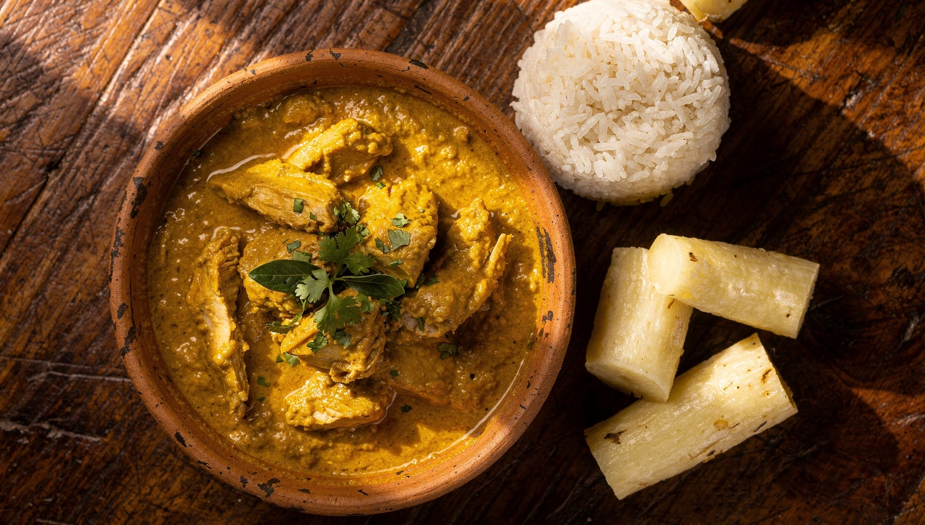 Pepián de pava lambayecano servido en plato de barro con arroz blanco y yuca cocida