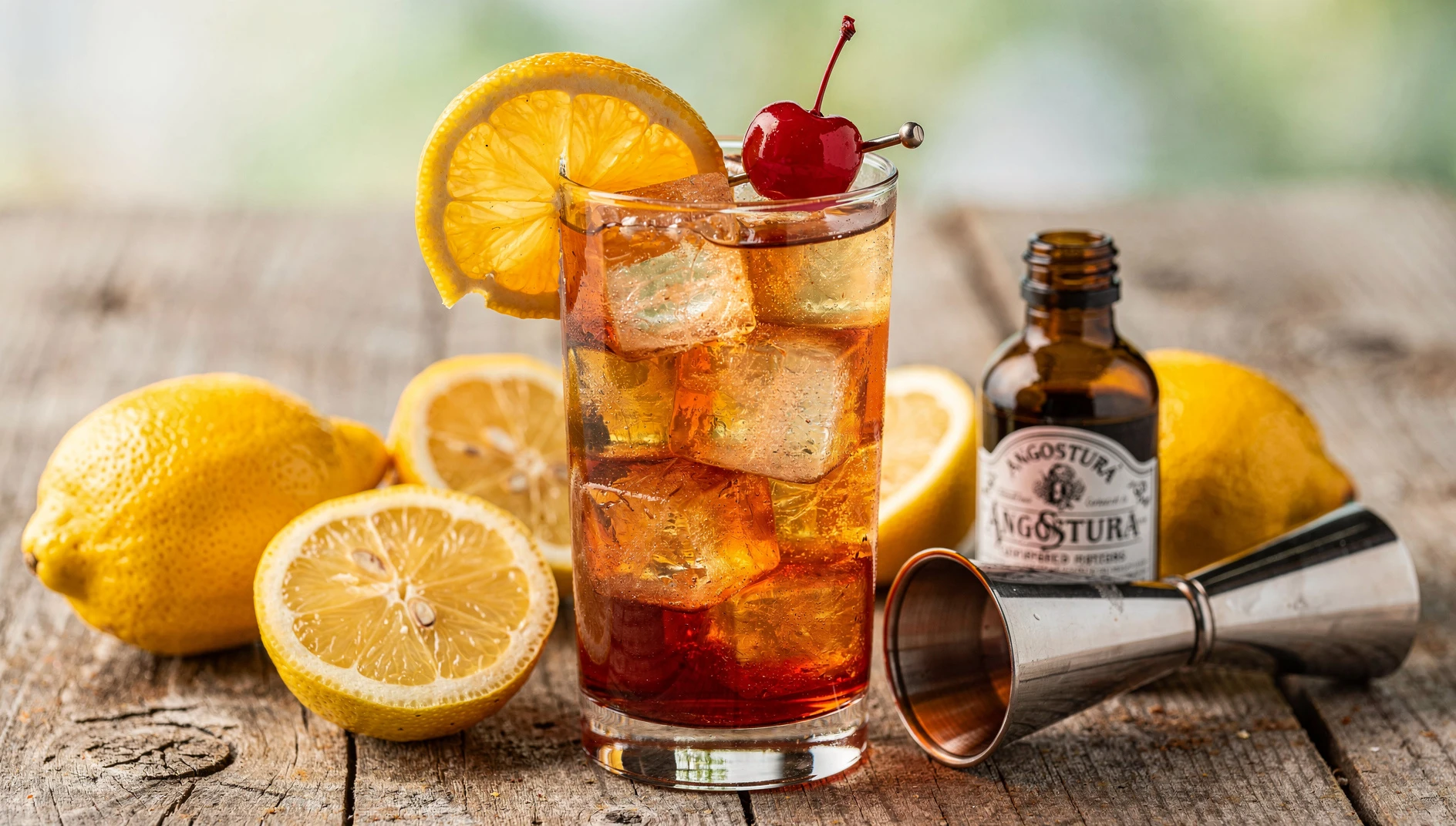 Planter's Punch servido en vaso alto con hielo, decorado con rodaja de naranja y cereza marrasquino