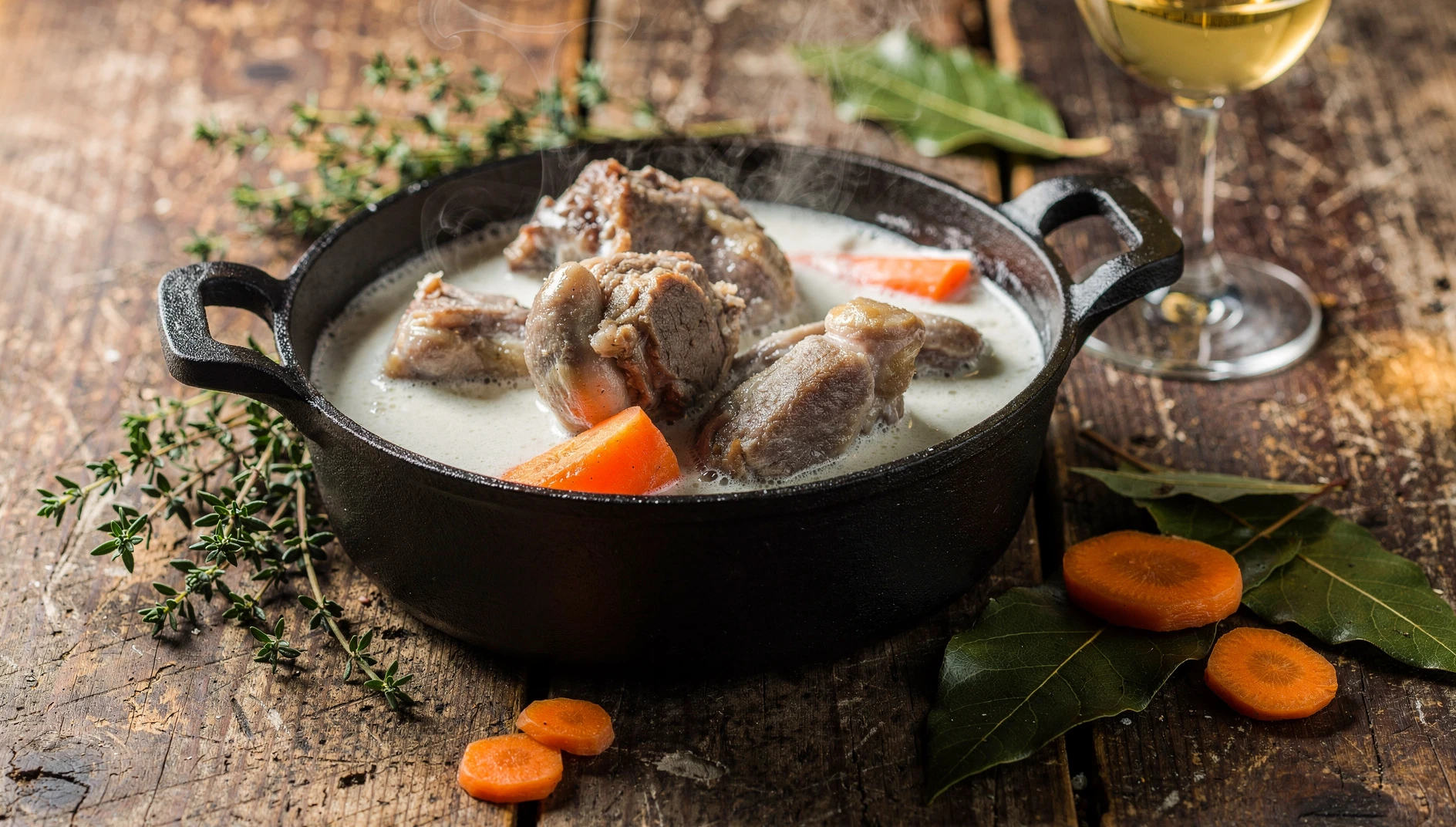 Tripous de Aveyron en salsa blanca servidos en cazuela de hierro con hierbas aromáticas y verduras