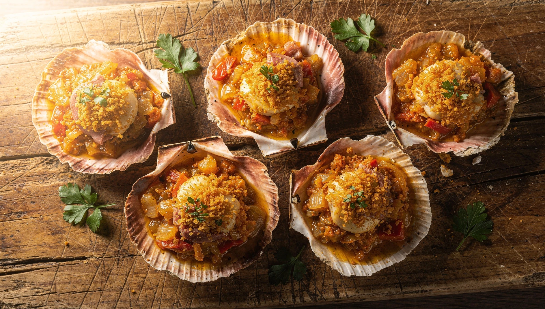 Vieiras a la gallega gratinadas en su concha con sofrito de cebolla, pimiento y pimentón