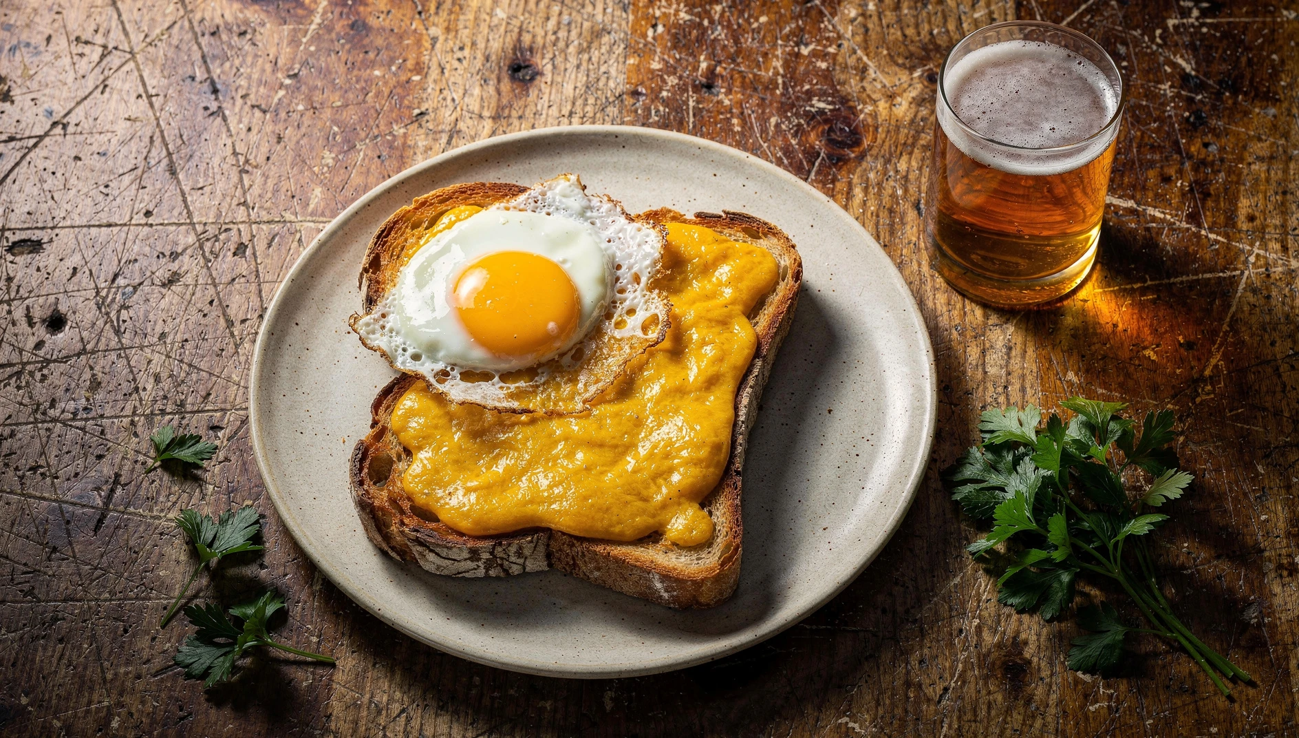 Welsh du Nord con salsa de cheddar fundido y cerveza, coronado con un huevo frito sobre pan tostado