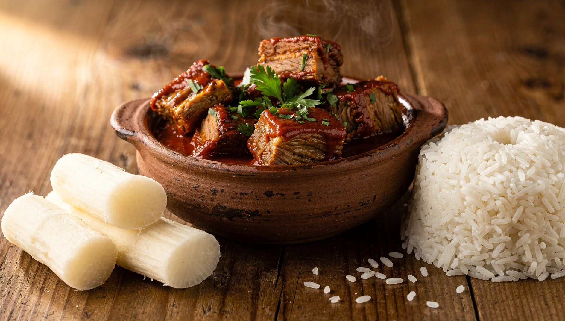 Lechona api sanmartinense servida en cazuela de barro con yuca cocida y arroz blanco