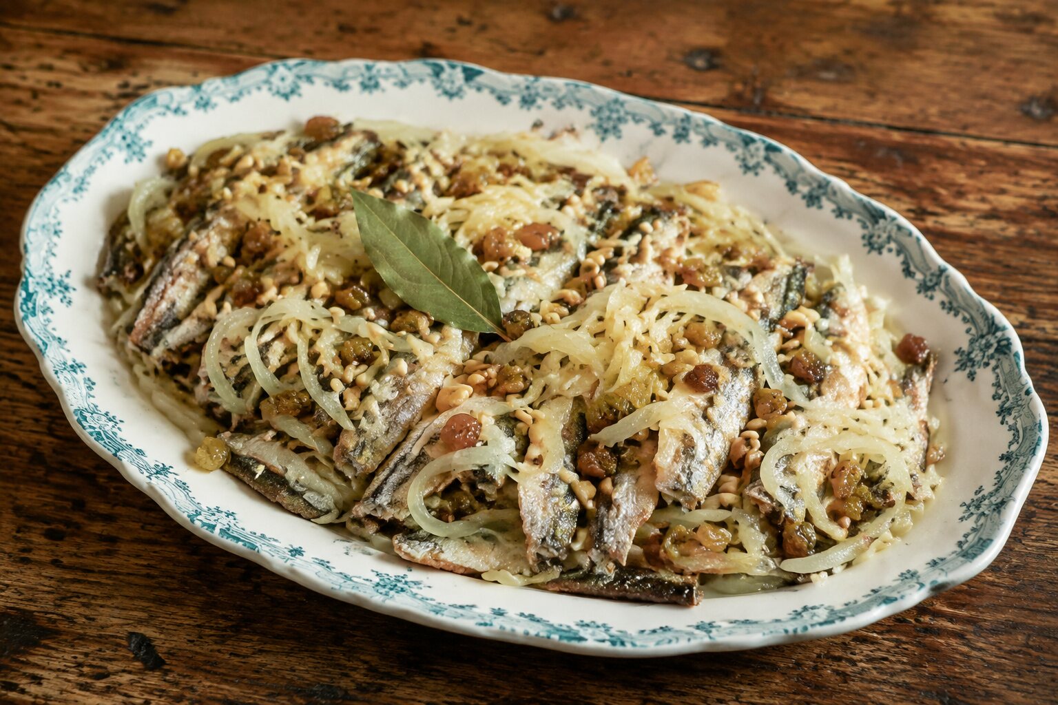 Sarde in saor con cebolla, pasas y piñones